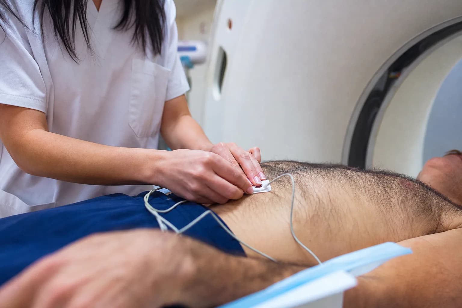 טכנאית דימות מכינה מטופל לבדיקת CT במכון דימות בבית חולים ישראלי